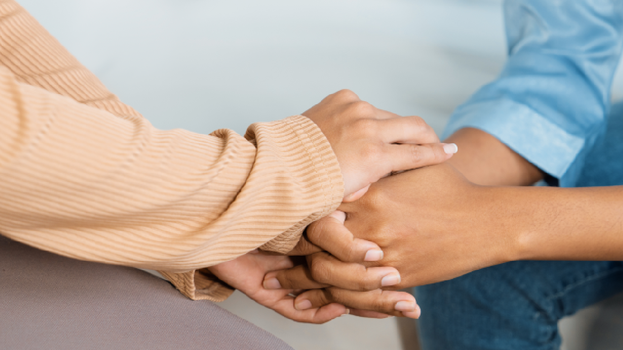 Two hands holding each other in comfort.